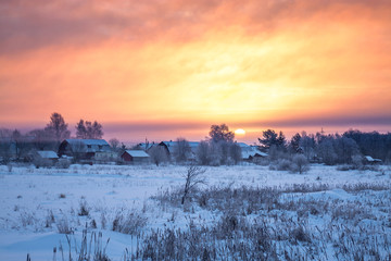 Wall Mural - winter rural landscape with village, sunrise and fog