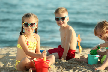 Wall Mural - Cute kids building sandcastles on beach