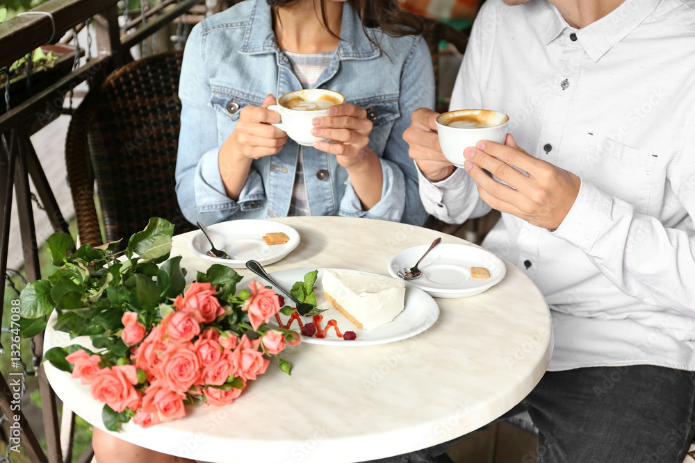 Young couple drinking coffee in cafe, close up view