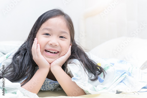 cute asian girl smile and lying on bed. Stock Photo | Adobe Stock