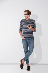 Full length Man in striped sweater holding phone