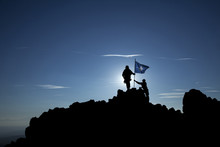 Two Soldiers Put The NATO Flag On Top Of The Mountain