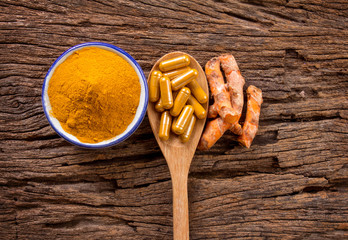 Poster - the turmeric powder , capsule and roots curcumin on wooden plate