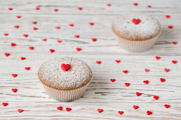 Two muffins decorated with red hearts