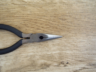 Pliers on wood background