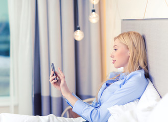 Canvas Print - happy businesswoman with smartphone in hotel room