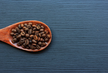 Wall Mural - Coffee beans and wood spoon on dark wood background