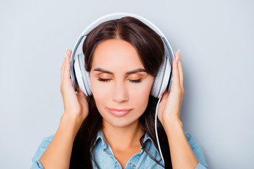 Wall Mural - Portrait of calm woman listening music in headphones with closed