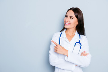 Canvas Print - Smiling happy doctor pointing with finger on blue background