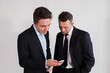 © kuzovkov - Young businessmen with the smartphone on a white background