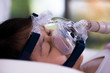 Obstructive sleep apnea therapy, Woman wearing CPAP mask.CPAP Continuous positive airway pressure  therapy.Happy and healthy senior woman breathing more easily during sleep  without snoring.