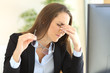 Businesswoman suffering eyestrain at office