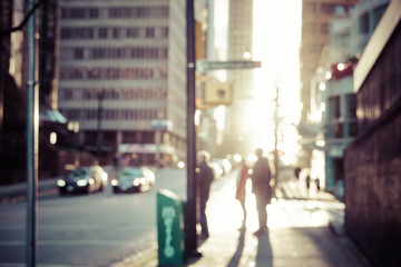 Blurred people walking on the street of Vancouver at sunset