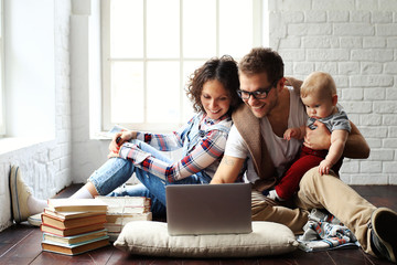 Wall Mural - Young happy family relaxing at home on the floor