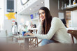 © zorandim75 - Freelance young woman sitting in the cafeteria with laptop and using mobile phone