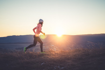 Wall Mural - Runner girl on top of the hill in sunset