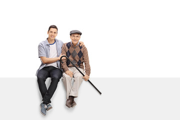 Wall Mural - Young man and a senior sitting on a panel together