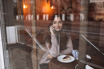 Sticker - Happy young woman in cafe while talking by her phone