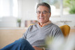 © goodluz - Smiling senior man with eyeglasses relaxing in armchair