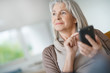 © goodluz - Senior woman relaxing and using smartphone