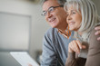 © goodluz - Senior couple at home using digital tablet