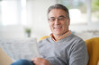 © goodluz - Smiling senior man with eyeglasses reading newspaper