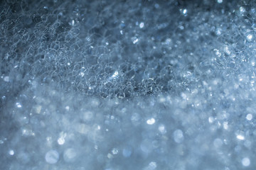 Closeup of foam with bubbles sticking together like a spider web.