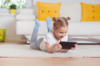 © spass - Pretty little girl  using a digital tablet, looking and smiling