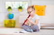 © spass - Portrait of pretty little girl with flute on floor