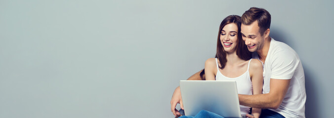 Beautiful young couple using laptop