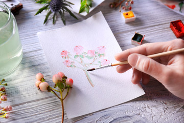 Sticker - Woman drawing flower on album sheet on wooden background