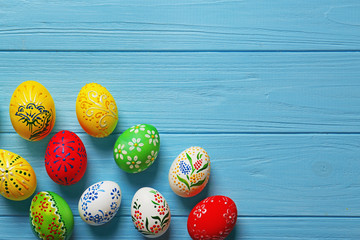 Wall Mural - Beautiful Easter eggs with floral ornament on blue wooden background