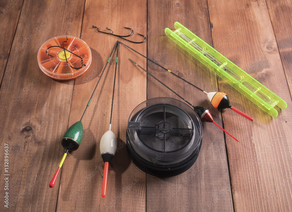 spool of fishing line, floats and a box of hooks Stock Photo | Adobe Stock