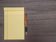 © danadestinations - Dark Wood Desk, Yellow Pad, Pen on Desk