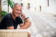 © Dragana Gordic - Business talk on a go. Cheerful man holding coffee cup and talking