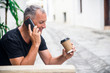 © Dragana Gordic - Shot of a stylish young man talking on mobile phone and having a cap of coffee