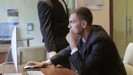 Top manager instructs an employee working at the computer