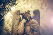 Statue of a beautiful angel. Olsany Cemetery, the largest graveyard in Prague, Czech Republic. Summer time with moody, dark sepia colors