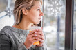 © Shadow - Woman drinking coffee and looking out the window. Close-up