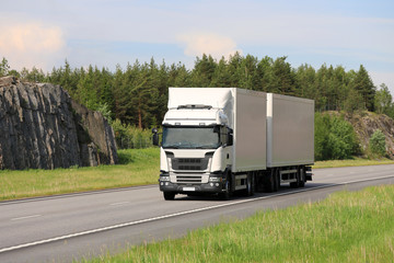 Wall Mural - Big White Rig Transports Goods along Freeway