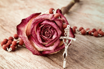 Silver crucifix  and dry rose