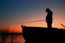 A Fisherwoman With A Fishing Rod Standing In Boat 