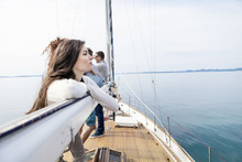 Young Woman Leaning Against Boom Of Sailboat