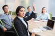 Confident young manager raising hand at workshop