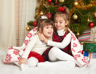 two girls portrait in christmas decoration, winter holiday concept, decorated fir tree and gifts