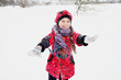 small girl playing with snow in winter weather