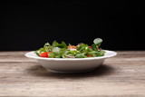 Fototapeta Tulipany - Frischer Salat mit Zwiebeln, Käse, Tomaten und Gurken aus Holzplatte