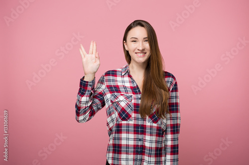 Cuadros en Lienzo hipster girl showing spock gesture over pink background isolated