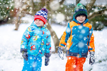 Happy children having fun with snow in winter