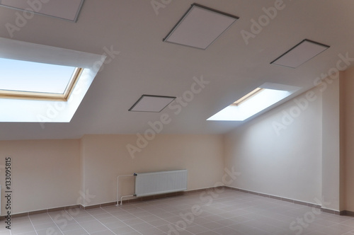 Modern Interior Of Attic Room With A Sloping Ceiling And Skylight